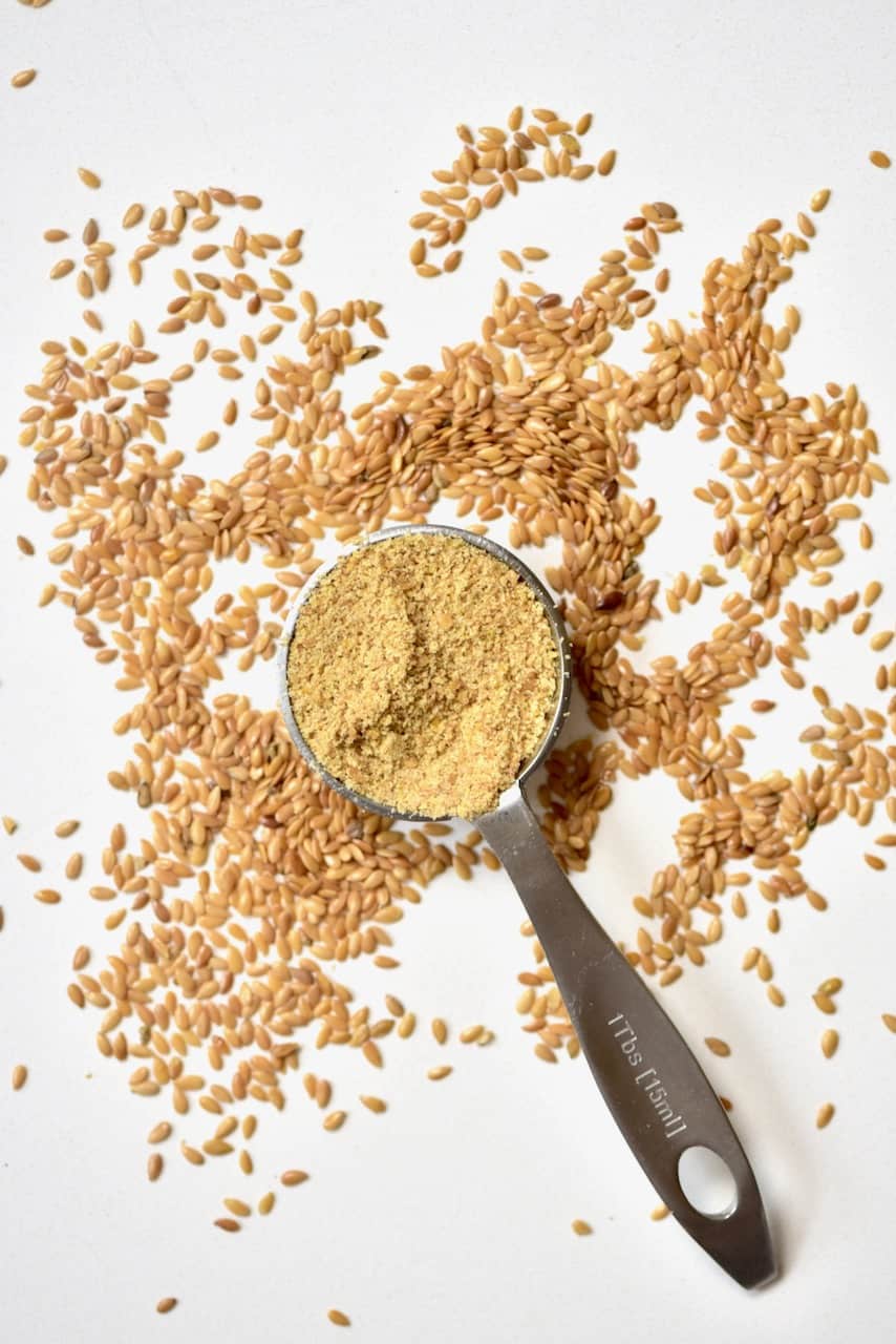 https://www.alphafoodie.com/wp-content/uploads/2020/06/Tablespoon-of-ground-Flaxseed-next-to-unground-flaxeed.jpeg