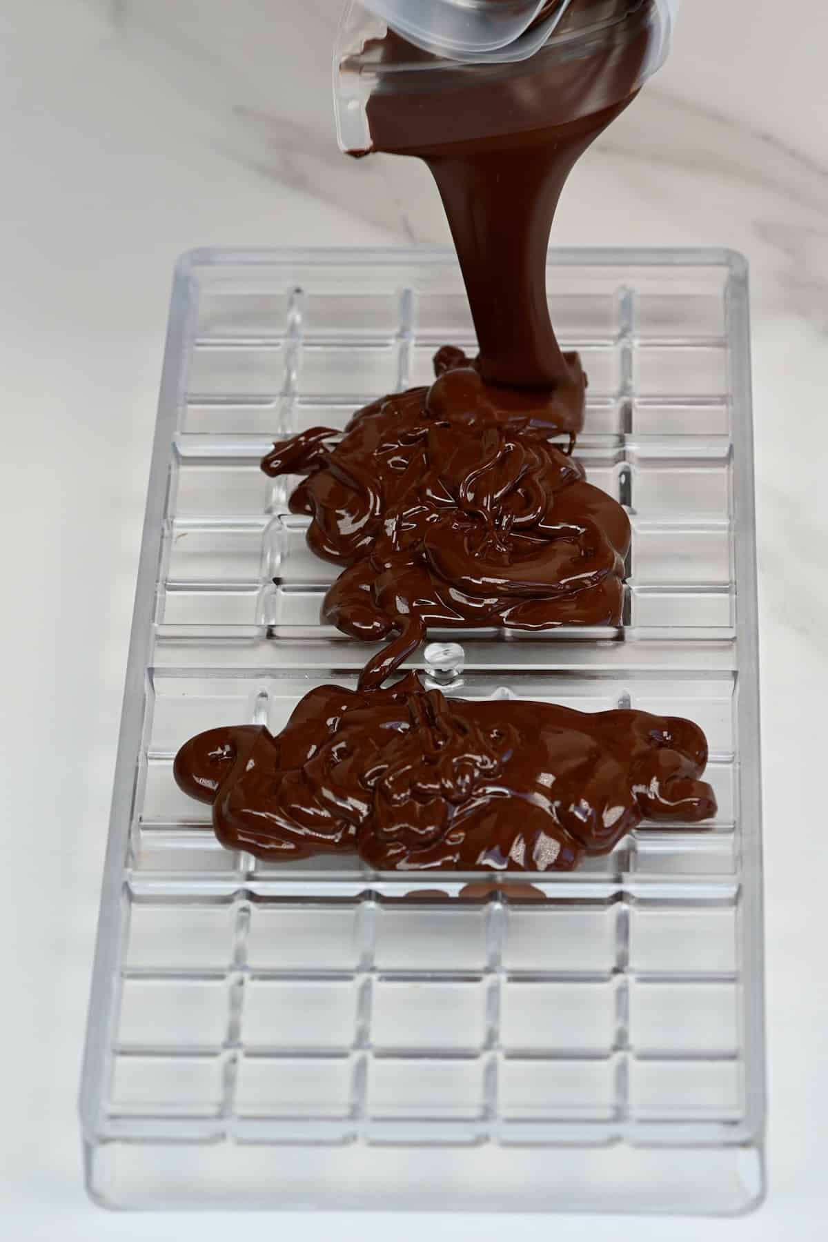 https://www.alphafoodie.com/wp-content/uploads/2021/04/Pouring-melted-chocolate-in-a-mold.jpeg