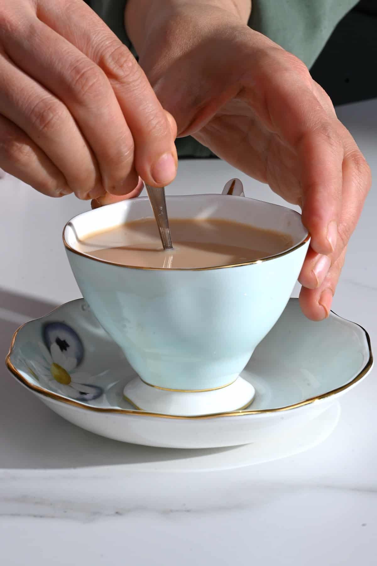 https://www.alphafoodie.com/wp-content/uploads/2022/03/Milk-Tea-Stirring-milk-tea-in-a-cup.jpeg