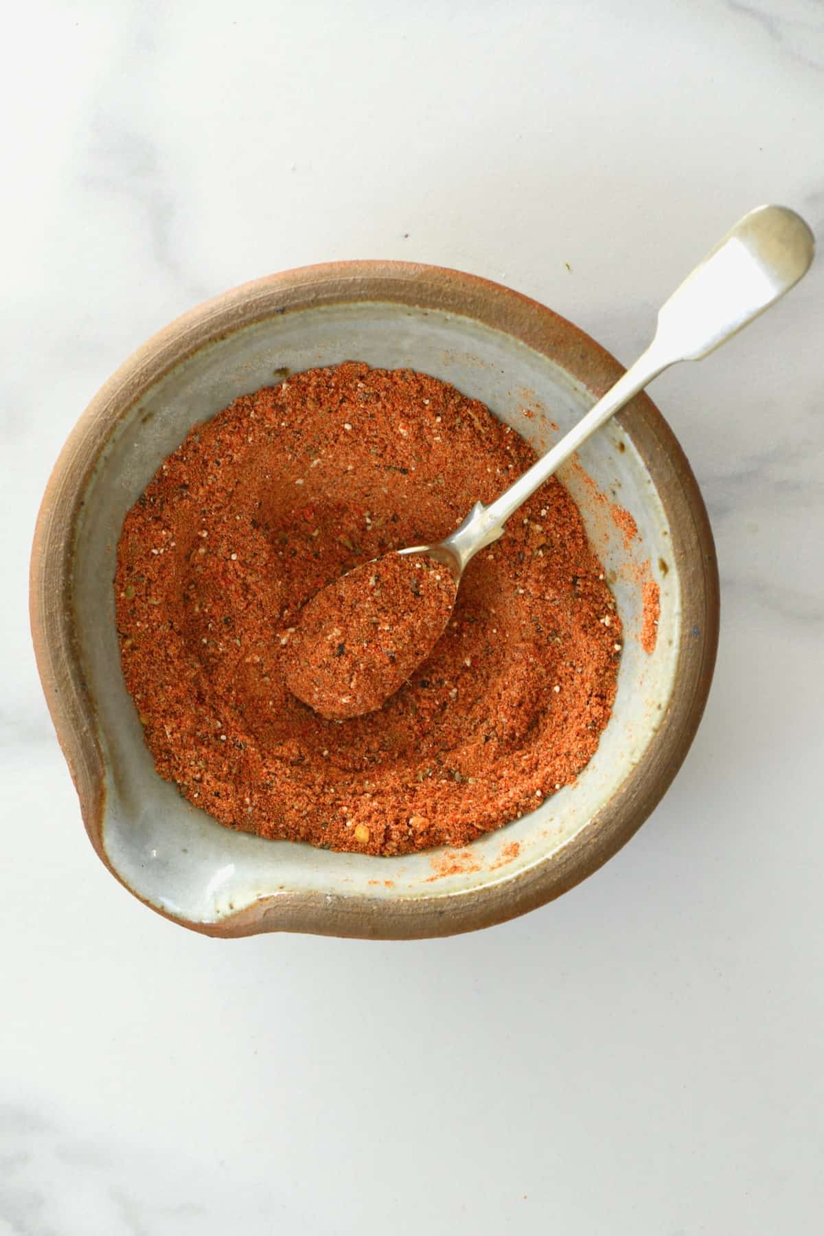 https://www.alphafoodie.com/wp-content/uploads/2022/07/Authentic-Taco-Seasoning-Spices-A-spoonful-of-taco-seasoning-in-a-bowl.jpeg