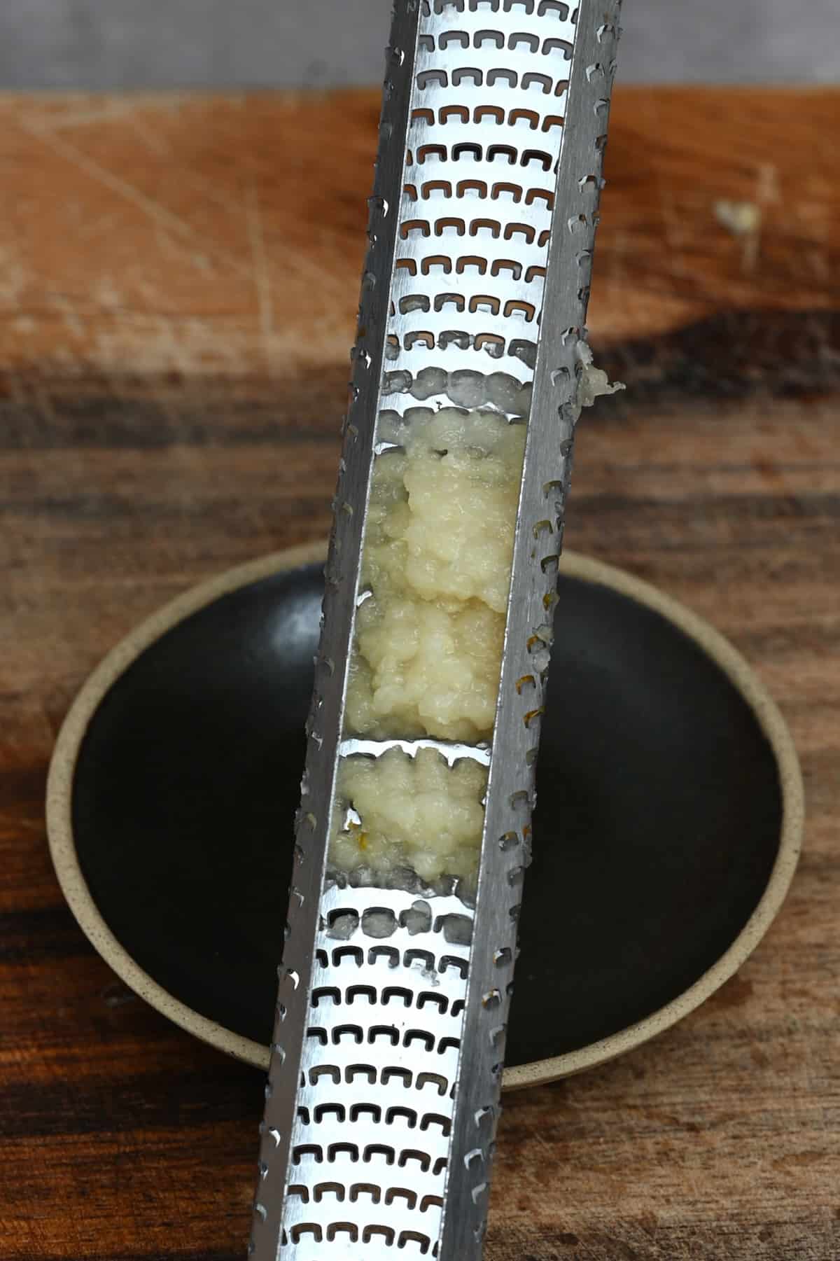 https://www.alphafoodie.com/wp-content/uploads/2022/11/Garlic-Guide-Garlic-grated-on-a-microplane.jpeg