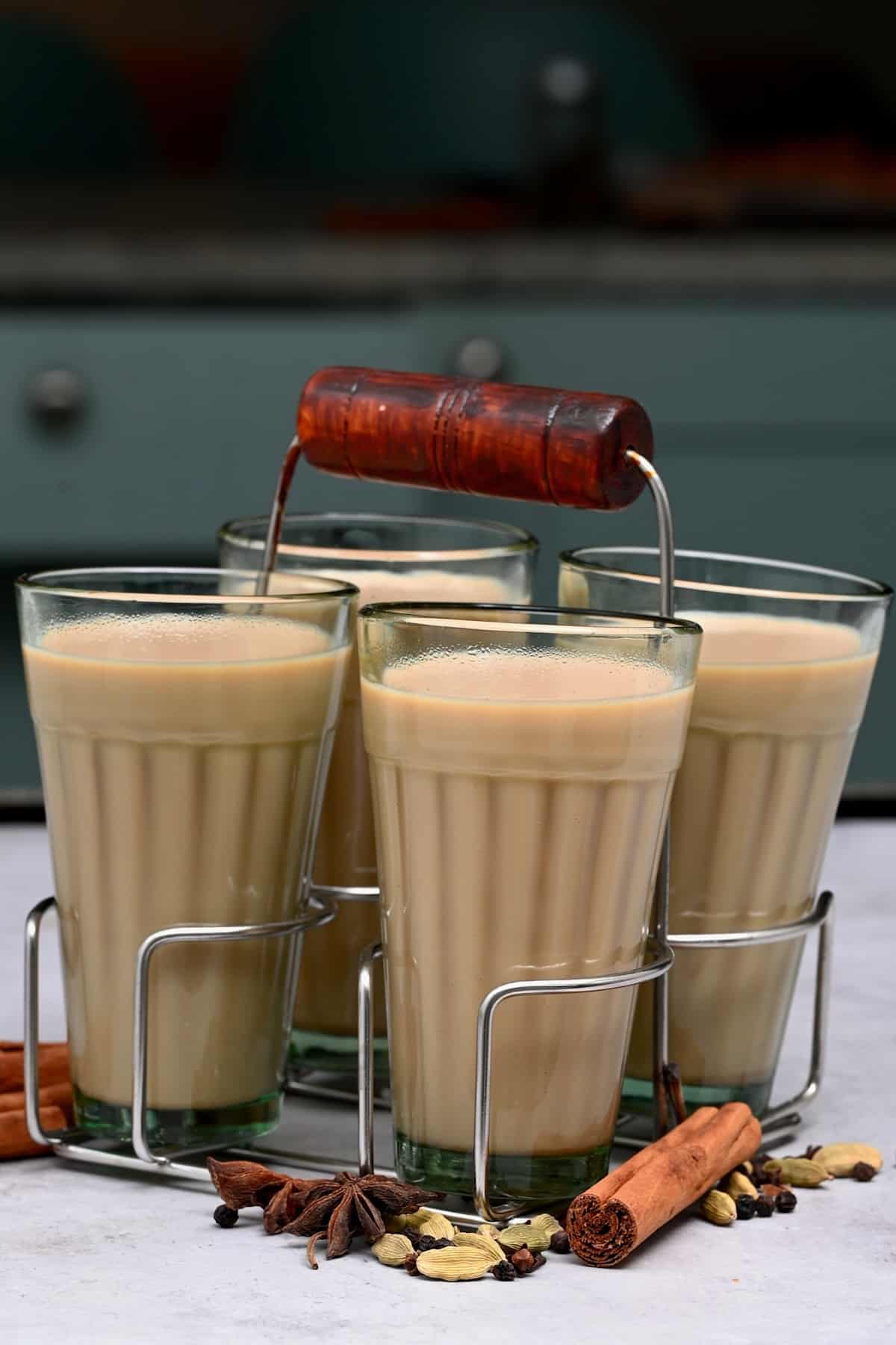 Indian chai in glass cups with metal kettle and other masalas to make the  tea. Stock Photo
