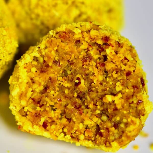 A half-eaten energy bite rolled into turmeric and coconut mix